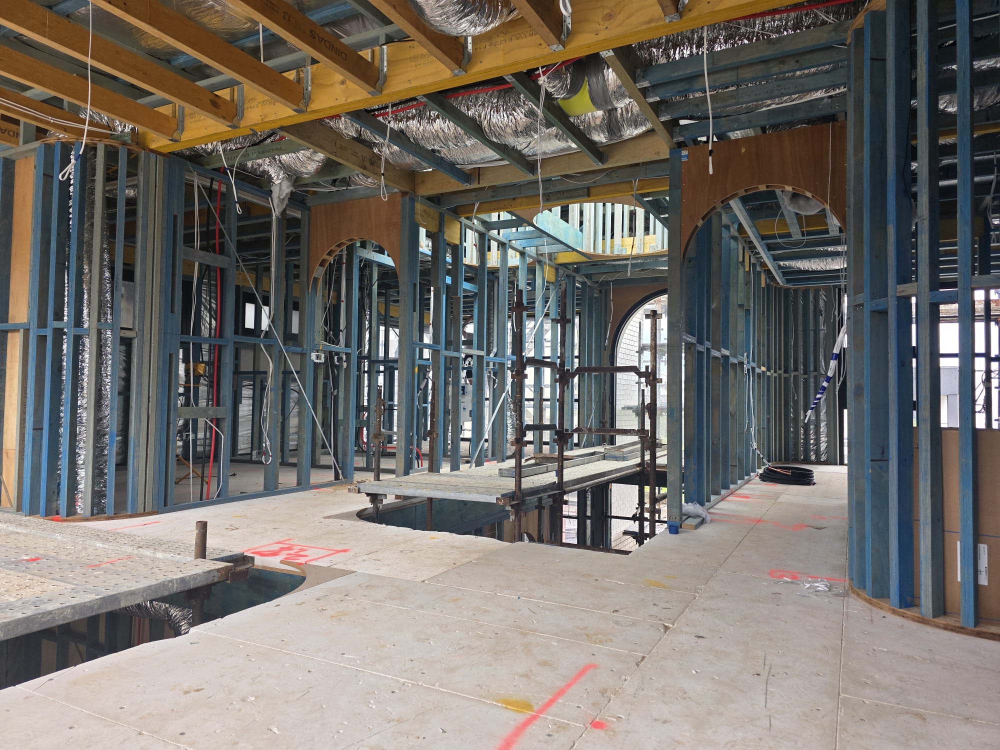 Internal steel and timber framing with curved archways and exposed floor joists