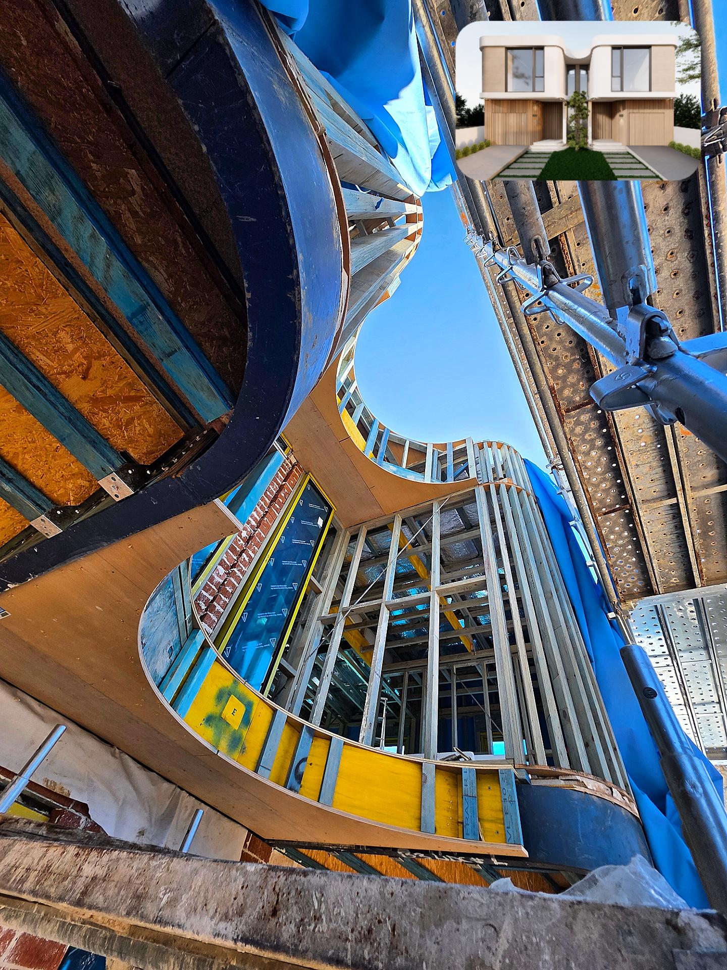 Worm's-eye view of a curved framed facade under construction behind scaffolding